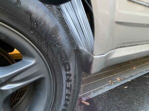 洗車時に足回りに水をかけて汚れを落とす様子