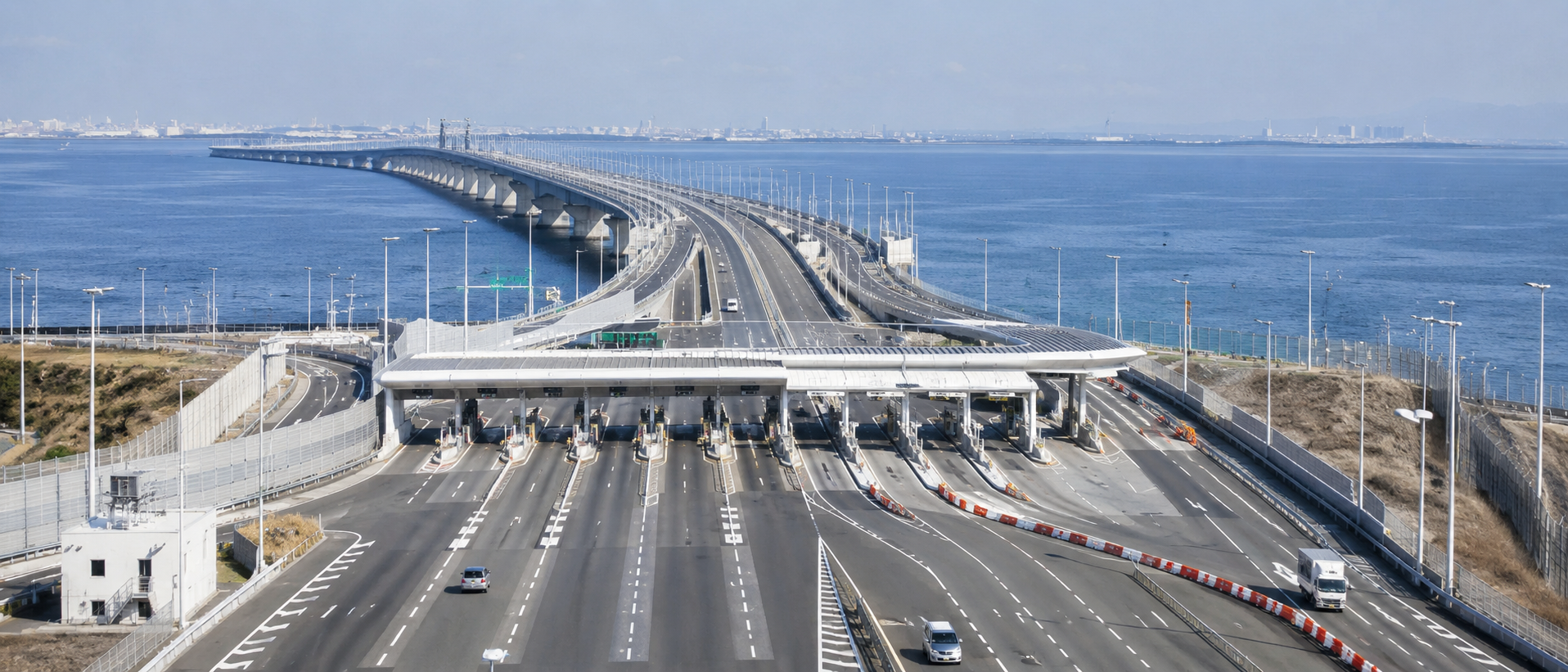 東京湾アクアラインの料金所や本線道路を遠方から捉えた、整然とした道路構造物の写真